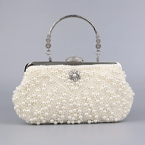 Detailed view of handmade bridal clutch with white pearls and rhinestone sun flower ornament