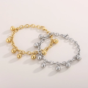 Close-up of gold and silver stainless steel rolo bracelets with polished spherical charms