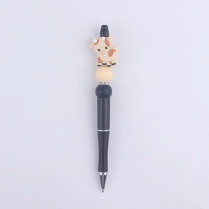 Detail of creative DIY cartoon cow silicone bead pen with black matte barrel and silver nib