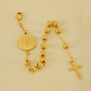 Golden stainless steel St. Benedict medal and cross bead bracelet on silk fabric
