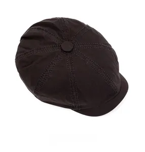 Top view of a cotton newsboy cap showing the stitched panels and top button