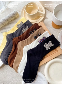 Close-up of ribbed cotton socks in various colors with rhinestone bear embellishments