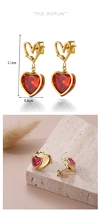 Detail view of heart drop earrings with red gems and dimensions 2.1cm by 0.8cm