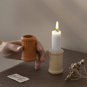 Detail of ribbed resin candle holder showing the vertical texture and a burning candle