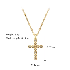 Detail shot of gold cross pendant with cubic zirconia gems and product dimensions