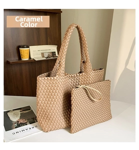 Detail of caramel hand-woven oversized tote bag and matching pouch in a French chic setting