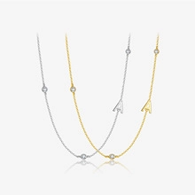 Detail of elegant gold and silver A letter necklaces with shimmering round zircons