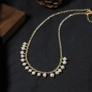 Elegant natural pearl necklace with gold chain on dark background with rustic decor