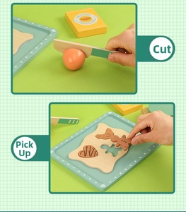 Detail of wooden play food set with sliced egg and cookie molds on a blue tray