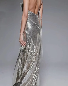 Detail of silver sequin evening gown with halter neck and open back on model