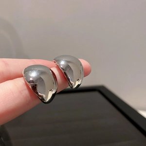 Close-up of silver water drop earrings with polished metallic finish and modern curved design