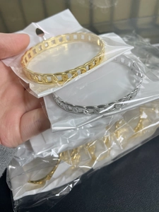 Detail shot of hollow chain bracelets in gold and silver finishes in OPP bags
