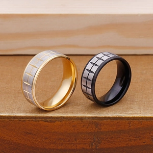 Detail view of gold and black tire tread pattern rings with a brushed metal finish