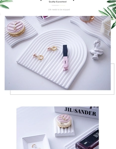 Macro detail of white plaster arch tray showing matte texture and wavy geometric design