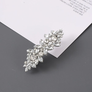 Macro detail of leaf-shaped rhinestone hair clip with sparkling marquise cut crystals