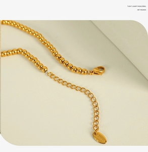 Détail macro de bijoux en perles d'or 18k avec fermoir homard et chaîne d'extension