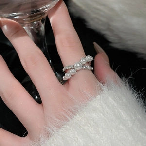 Close-up of elegant double-layered crossover ring with pearls and pavé cubic zirconia