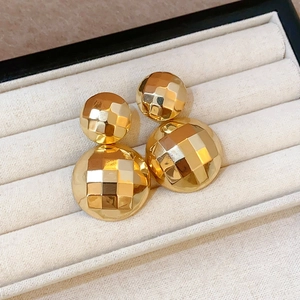 Detail von goldenen, facettierten Doppel-Kugel-Ohrringen in einer Samt-Schmuckbox