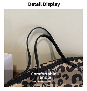 Close-up of leopard print canvas tote bag with black leather handle and metal rivet details