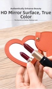 Detail of heart-shaped portable makeup mirror with orange leather case and high-definition reflection