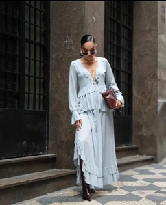 Detail of light blue V-neck maxi dress with layered ruffles and flowing fabric
