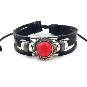 Close-up of vintage multi-layer leather bracelet with red stone inlay and silver beads