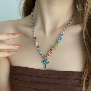 Blue cross necklace with colorful crushed stones and silver chain on female model