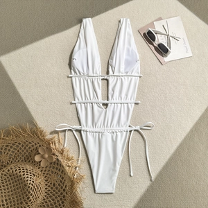 Detailed view of white one-piece swimsuit with cutout sides and lace-up drawstring design