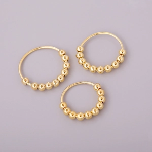 Macro view of three golden spinning bead rings for anxiety relief and minimalist style