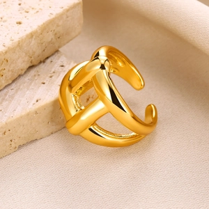Detailed close-up of a gold-plated adjustable knot ring on a textured stone and silk base