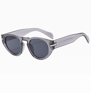 Detail view of silver arrow metal hinges on grey translucent round sunglasses frame