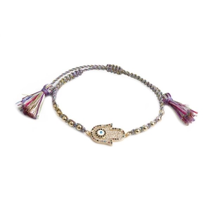 Détail de bracelet tressé œil maléfique avec breloque Hamsa dorée et pompons colorés