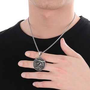 Silver Viking wolf head pendant necklace on model with moon and star embossed details