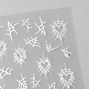 Detail of Halloween nail stickers with white spider web and heart patterns on clear film