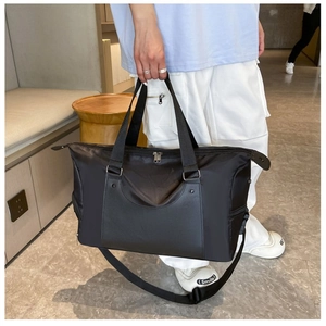 Detailed view of the large capacity black fitness bag with reinforced handles and shoulder strap