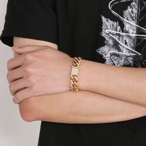 Nahaufnahme eines goldfarbenen Panzerarmbands mit Zirkonia-Steinen und Schnallenverschluss