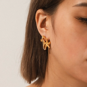 Boucles d'oreilles étoile de mer et hippocampe en acier doré avec strass sur modèle
