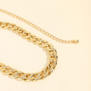Close-up of golden acrylic waist chain with thick cuban links and adjustable bead