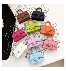 Flat lay view of colorful mini beaded crossbody bags in various litchi texture colors
