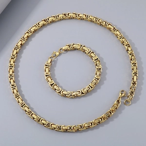 Macro shot of 8mm Byzantine chain necklace and bracelet with Greek key pattern in 18K gold
