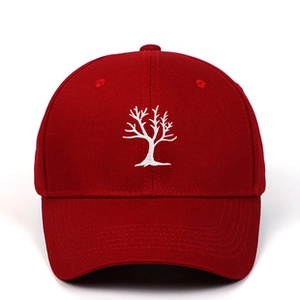 Detail of deep red vintage baseball cap with white embroidered tree logo and breathable vents