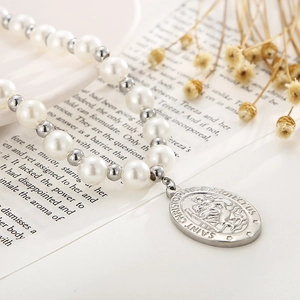 Vue macro du collier avec pendentif Saint Christophe avec perles blanches et billes d'argent