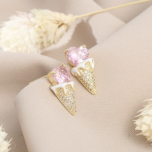 Close-up of pink heart zircon ice cream studs with gold cones and sparkling crystals