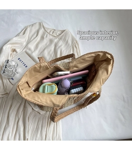 Spacious straw tote interior showing a bottle, umbrella and phone in a large compartment