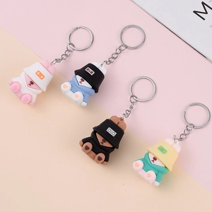 Set of four colorful PVC bear keychains wearing bucket hats and hoodies on a pastel backdrop