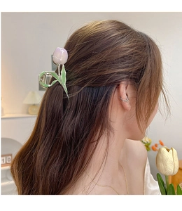 Detail of purple tulip hair claw clip worn by a model in a soft indoor setting