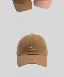 Close-up of a brown baseball cap featuring detailed Corgi embroidery on cotton twill