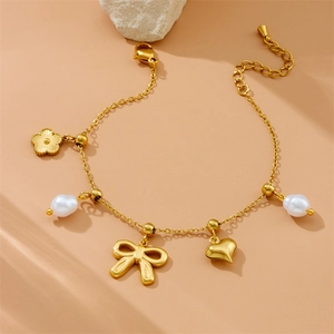 Bracelet doré avec breloques fleurs, perles, cœurs et nœuds sur fond beige élégant