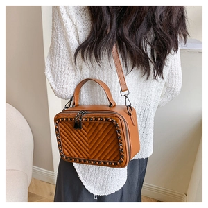 Dettaglio borsa a scatola in pelle marrone con trapuntatura a V e catena nera decorativa