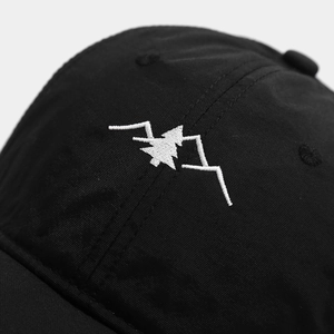 Close-up of white mountain and forest embroidery on black quick-dry baseball cap